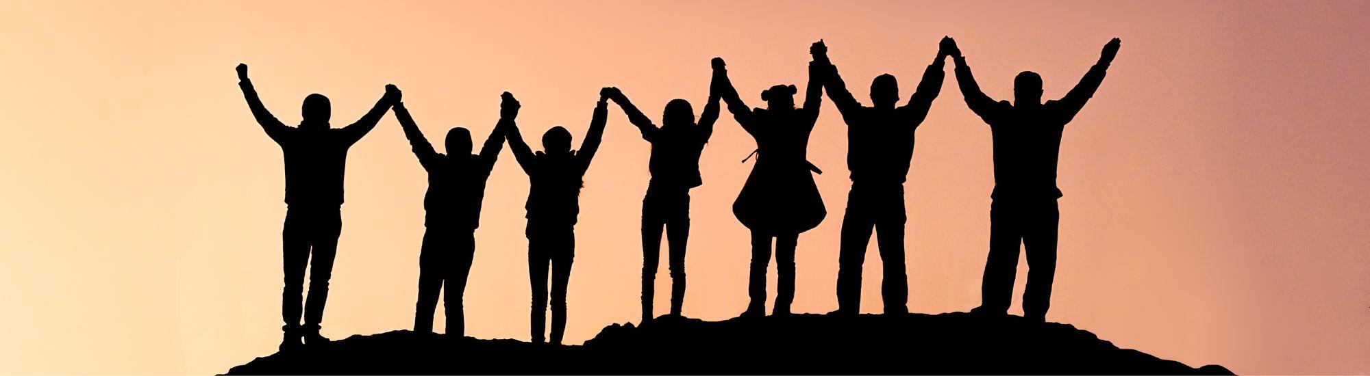 seven shadowed people standing with arms raised holding hands